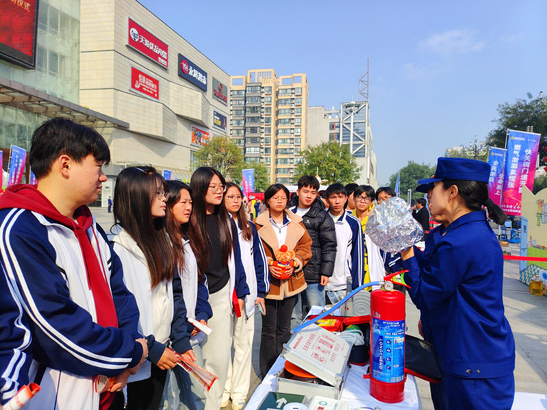 消防员向学生讲解防烟面罩的使用方法