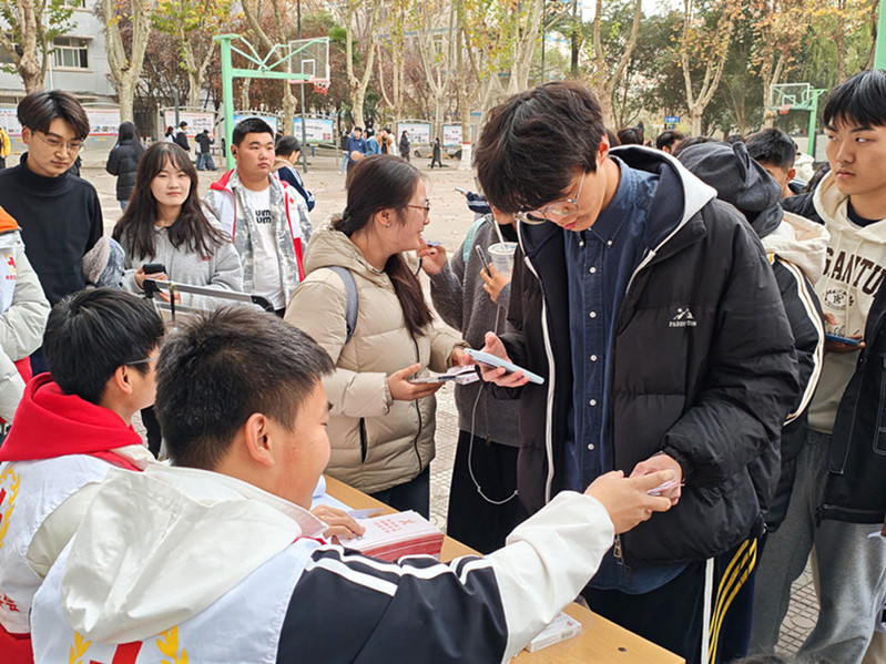 学校红十字协会会员为参加活动的学生免费发放科普宣传资料和防护物资