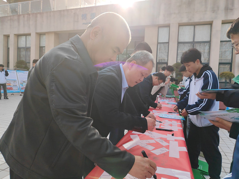 与会嘉宾在节水倡议横幅上签字