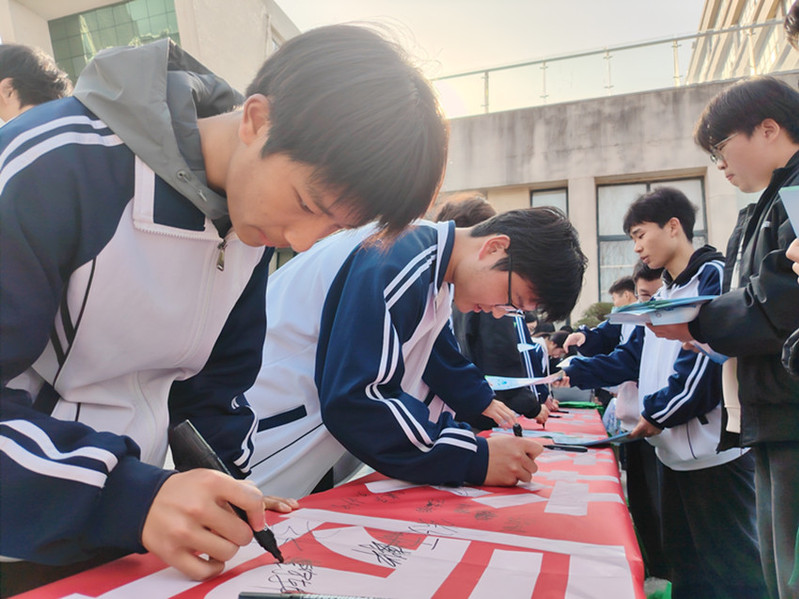 学生在节水倡议横幅上签字
