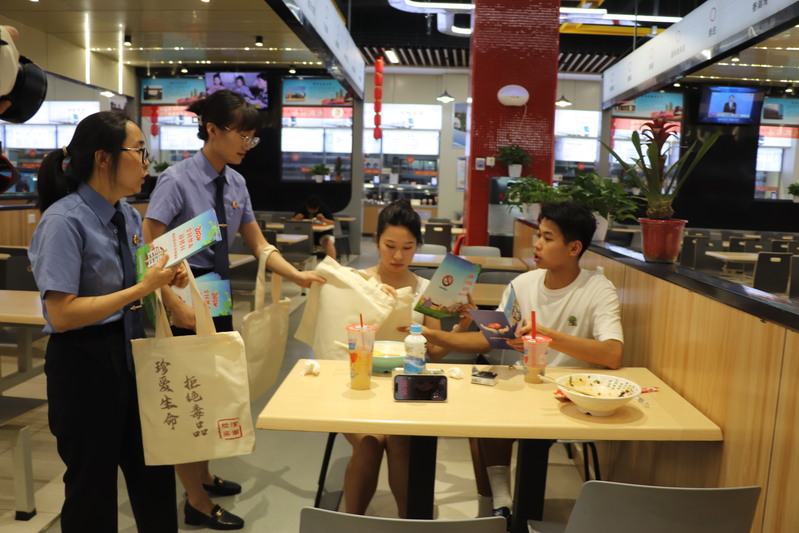 走进餐厅向学生发放禁毒宣传折页