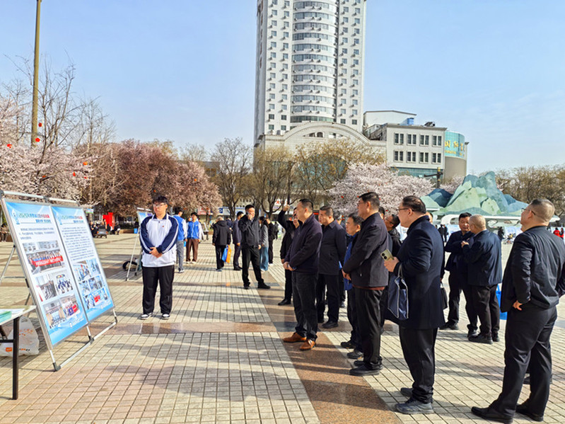 与会领导与嘉宾驻足观看我校节水宣传展板，详细了解我校在节水型校园建设方面的实践与成效。