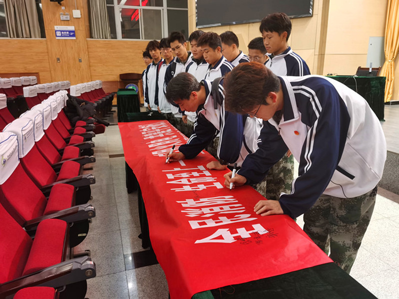 学生代表分批次在消防主题横幅上签字