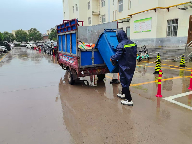 边飞飞在雨天清运垃圾