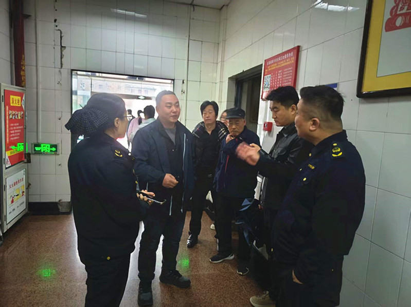 工作人员在楼道内，检查消防设施与疏散通道，筑牢安全防线。