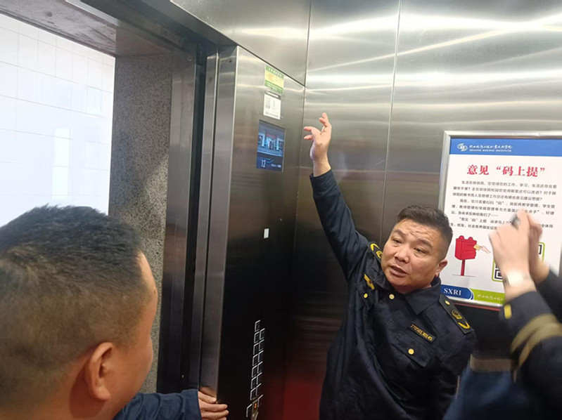 工作人员在电梯轿厢内，检查楼层显示及设备运行情况。