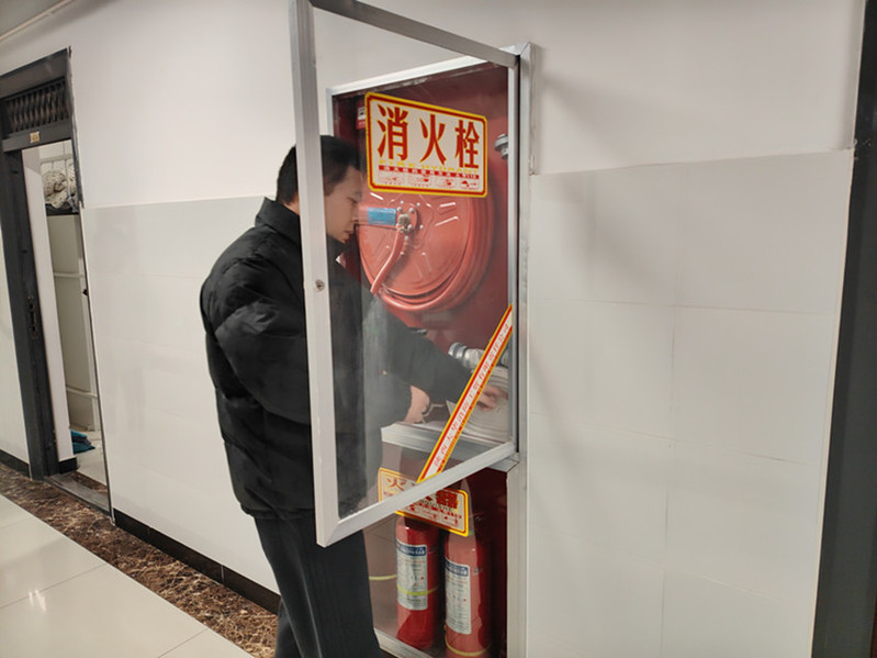 检查组成员在检查公寓消火栓