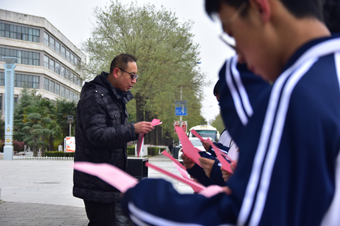 安保干部向学生发放交通安全宣传彩页