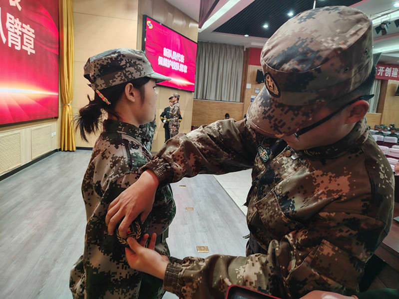 老队员为新队员佩戴护校队臂章